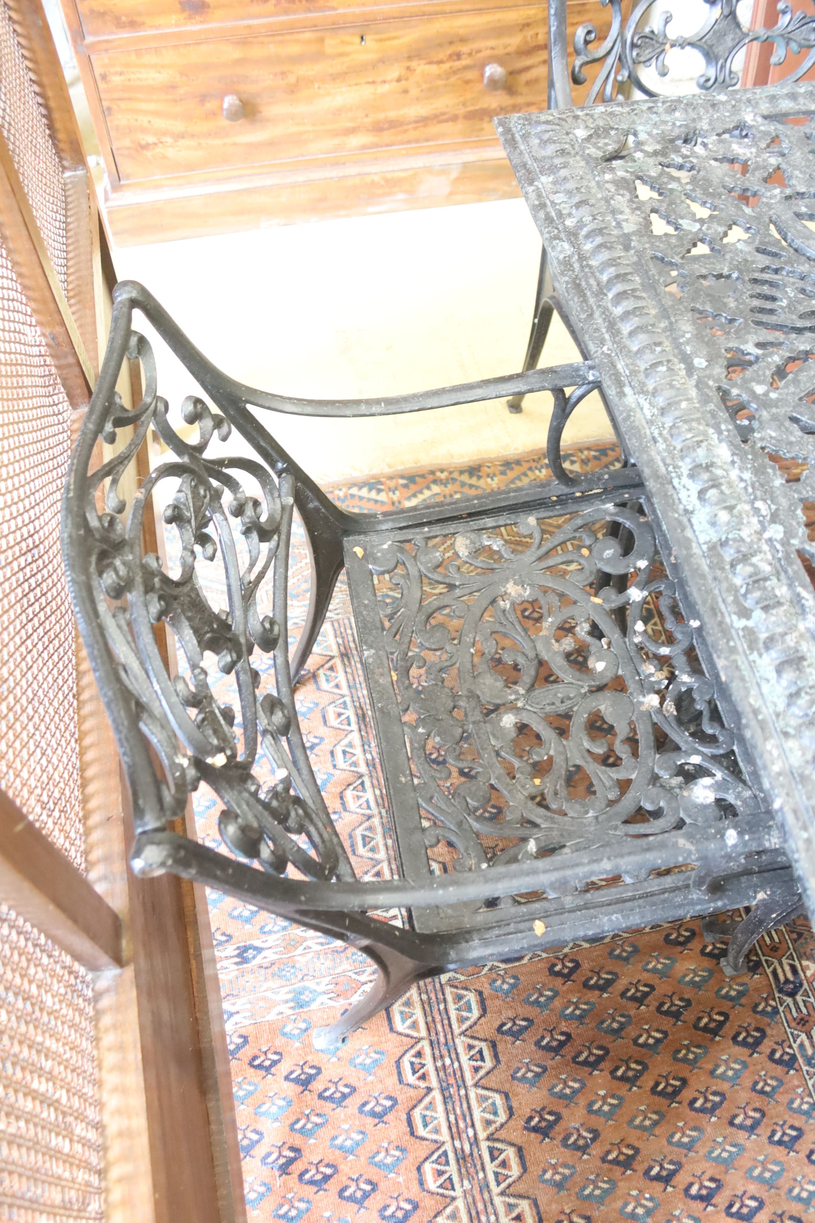 A Victorian style square cast metal garden table, width 88cm, height 72cm and four elbow chairs (one a.f.)